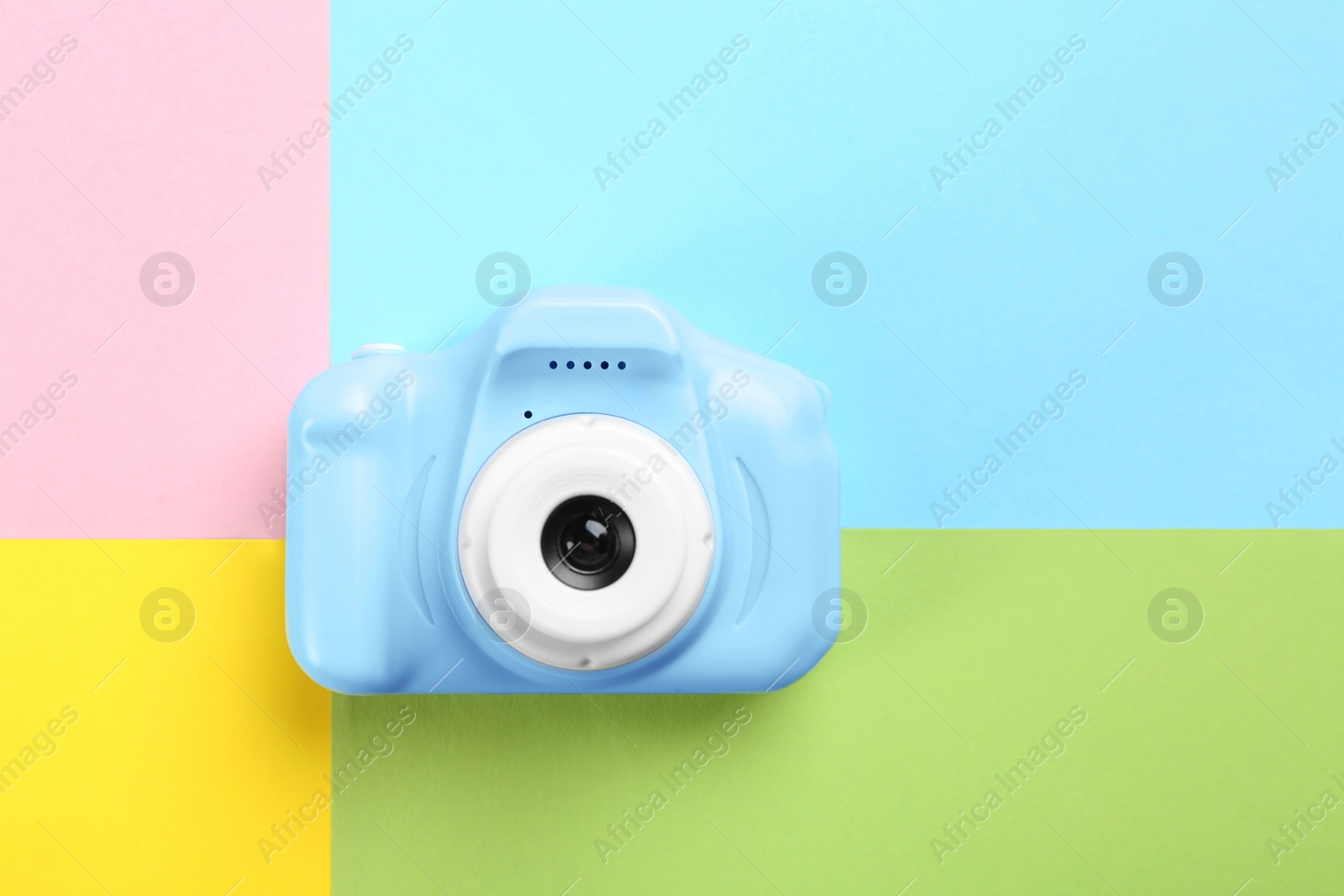 Photo of Light blue toy camera on color background, top view