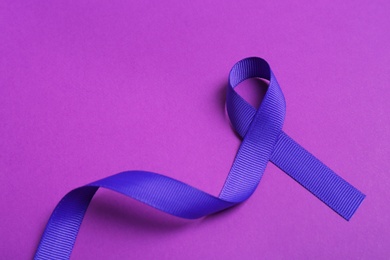 Satin purple awareness ribbon on color background