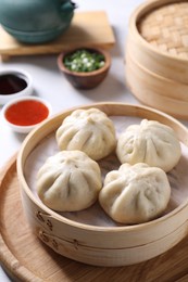 Photo of Delicious bao buns (baozi) on light table, closeup