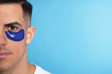 Photo of Man with under eye patch on light blue background. Space for text