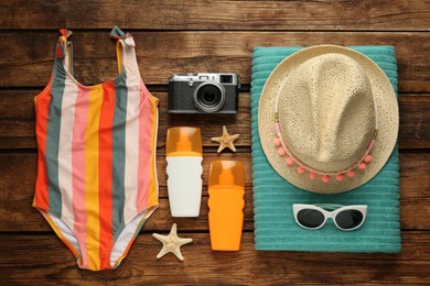 Photo of Different beach objects on wooden background, flat lay