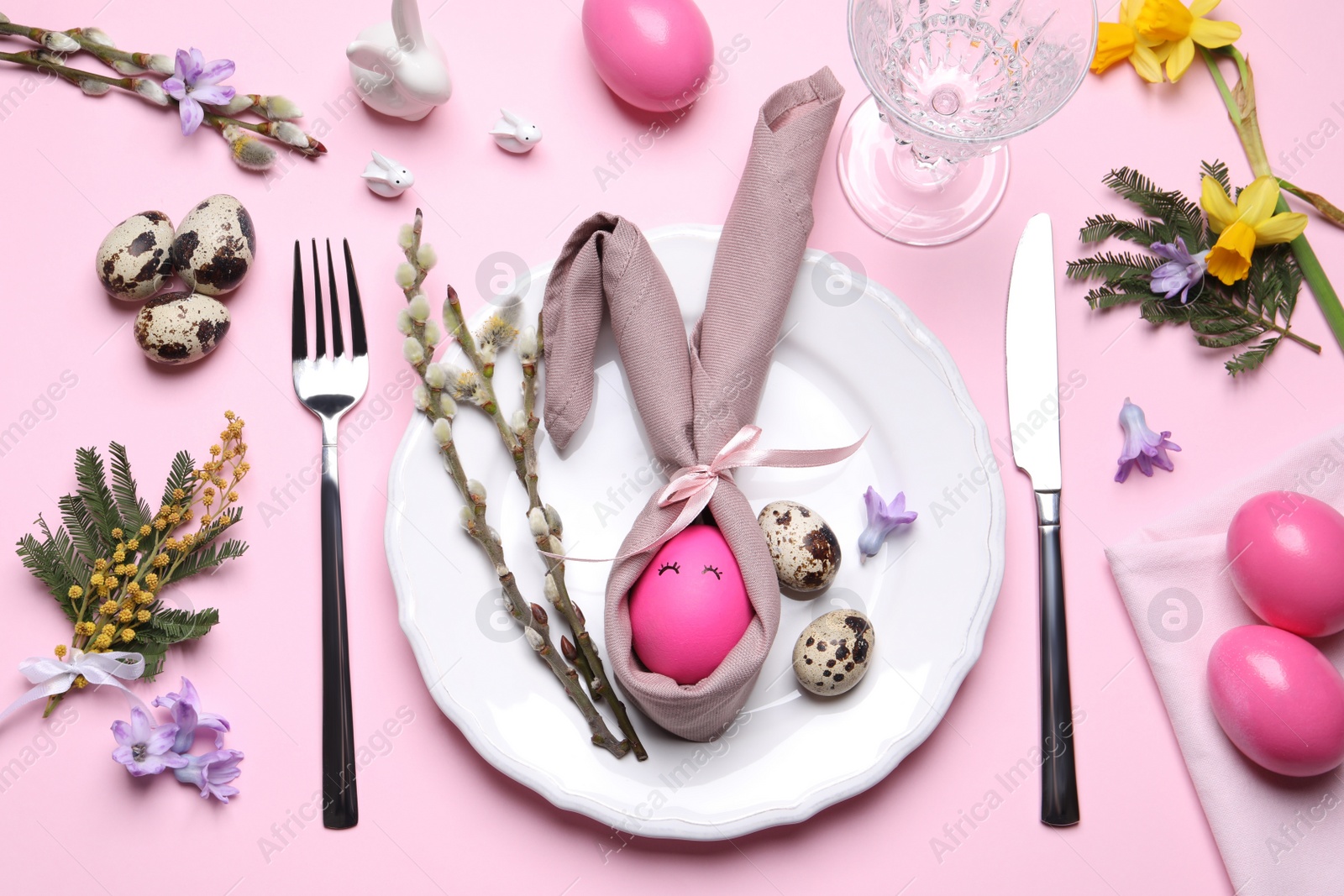 Photo of Festive Easter table setting with eggs on pink background, flat lay