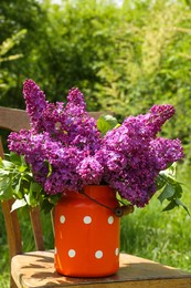 Beautiful lilac flowers in milk can outdoors