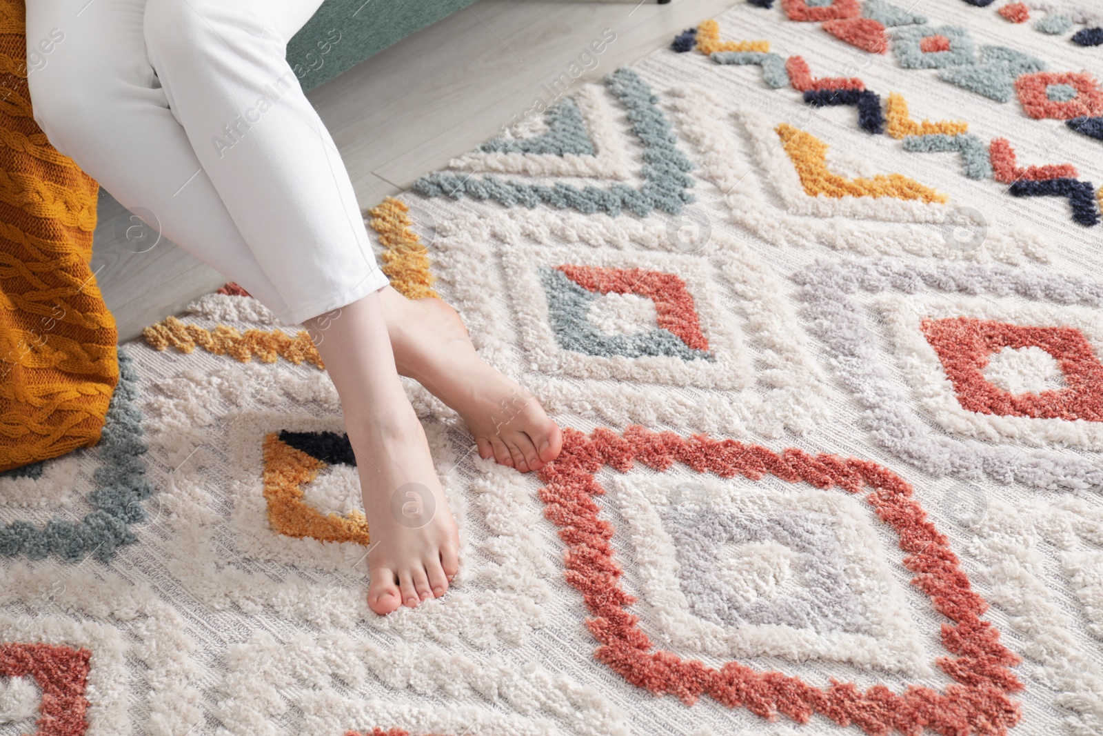 Photo of Woman on carpet with pattern at home, closeup. Space for text