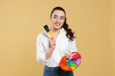 Photo of Woman with painting tools on beige background. Young artist