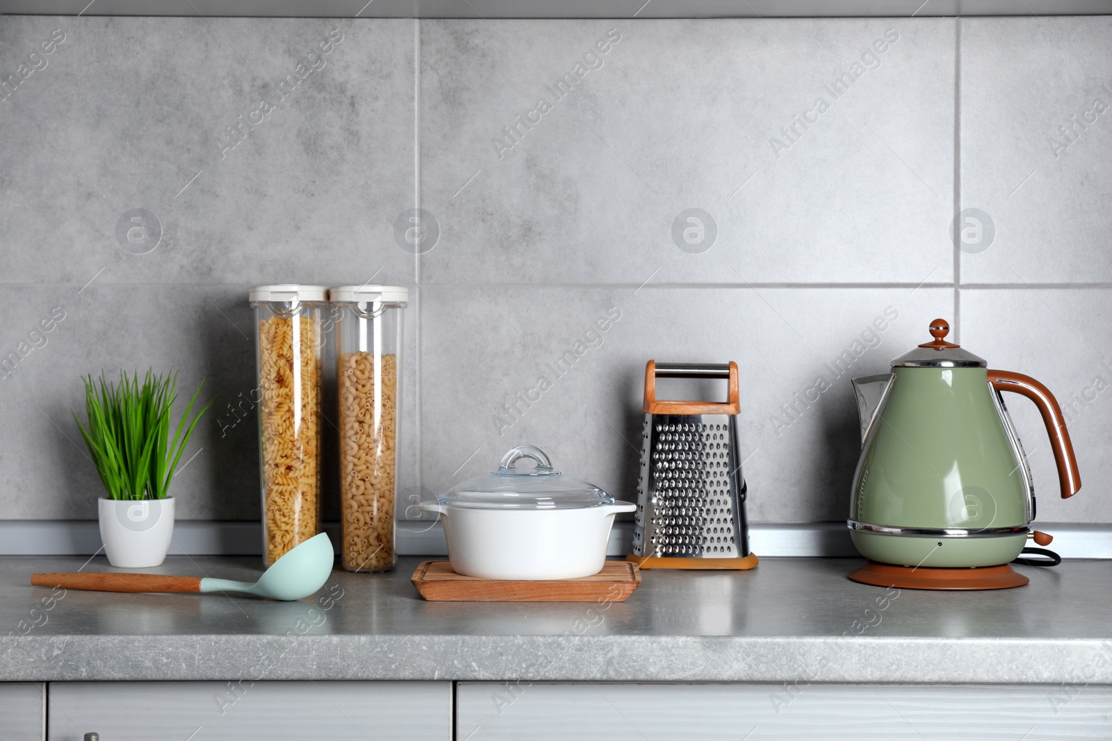 Photo of Set of different cooking utensils on grey countertop in kitchen