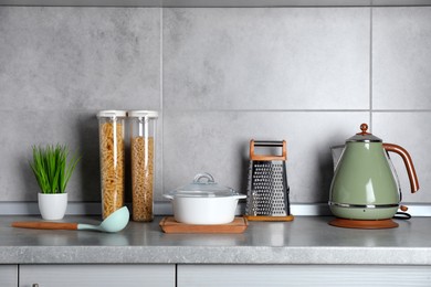 Photo of Set of different cooking utensils on grey countertop in kitchen