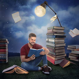 Image of Handsome young man reading and flying books in mystery park