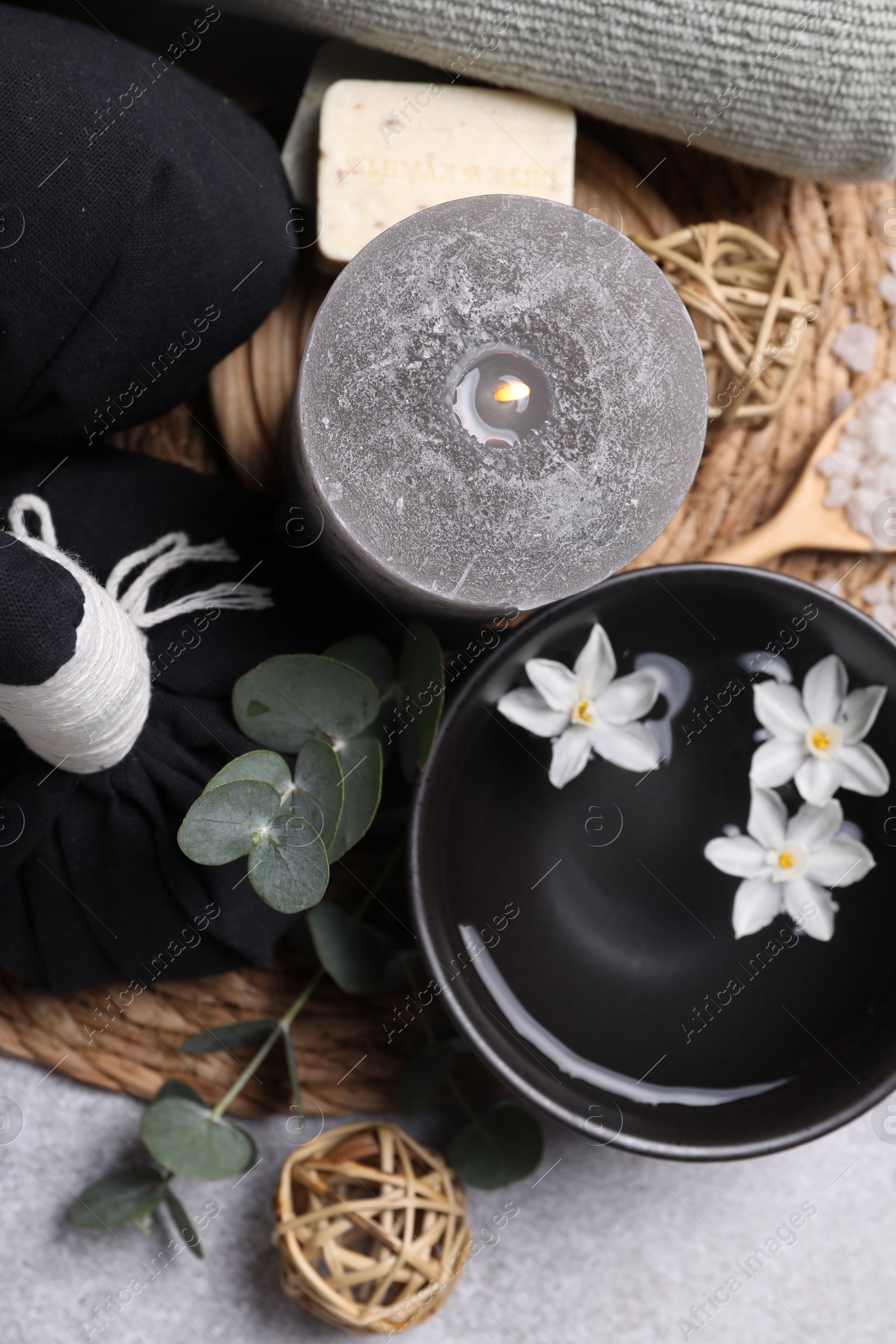 Photo of Beautiful composition with burning candle and spa products on light grey table, flat lay