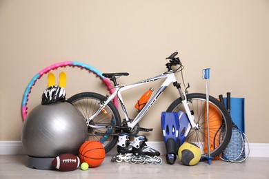 Photo of Bicycle and different modern sport equipment near beige wall