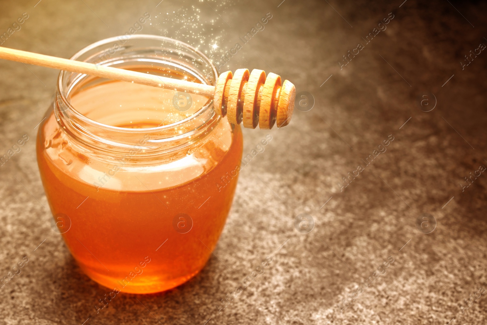 Image of Natural honey in glass jar and dipper under sunlight, closeup. Space for text