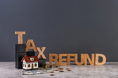 Photo of Phrase TAX REFUND, model of house and money on table