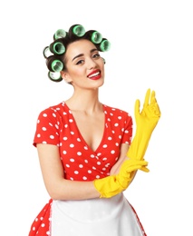 Funny young housewife with hair rollers putting on rubber gloves against white background