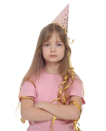 Photo of Unhappy little girl in party hat with crossed arms on white background