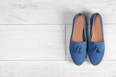 Photo of Pair of female shoes on wooden background, top view