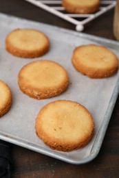 Photo of Tray with tasty sweet sugar cookies on wooden table, closeup