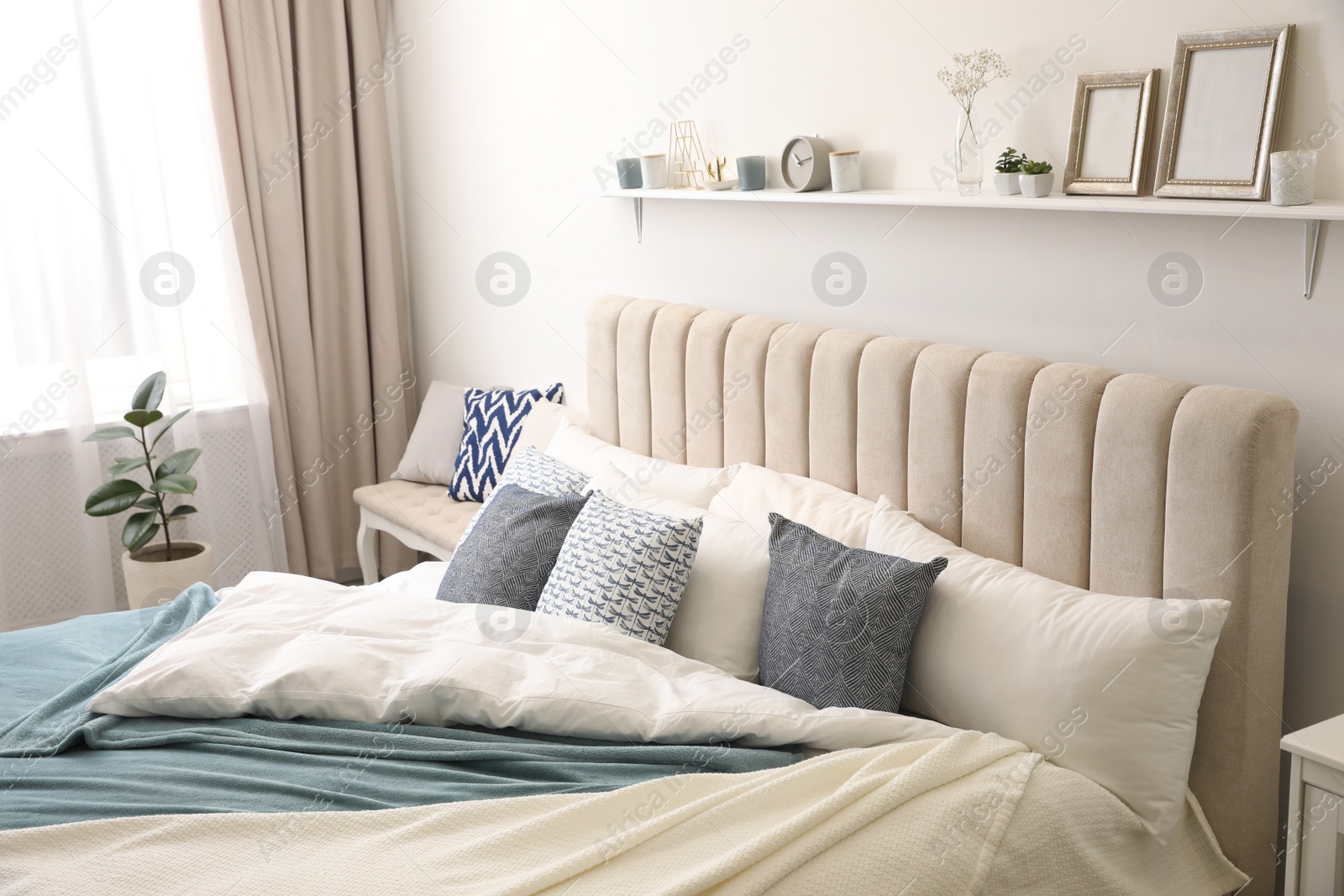 Photo of Comfortable bed with pillows in room. Stylish interior design