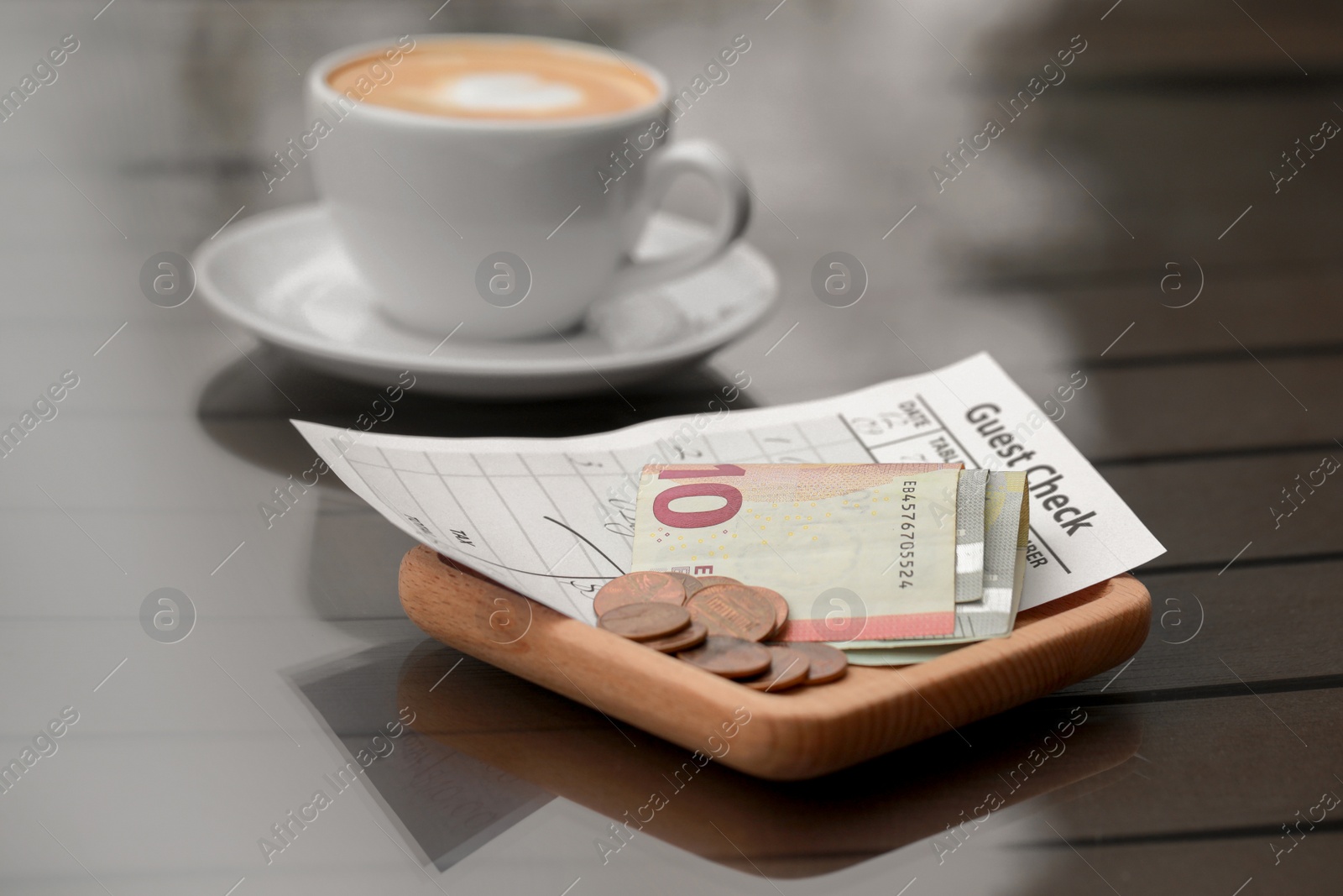Photo of Tips, receipt and cup of coffee on table