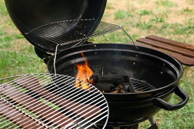 Photo of Modern barbecue grill with fire flames outdoors