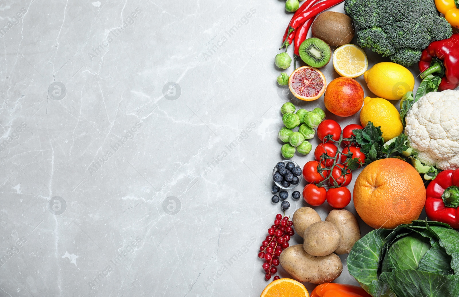 Photo of Different products  rich in vitamin C on light grey marble table, flat lay. Space for text