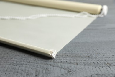 Photo of Stylish roller window blinds on grey wooden table