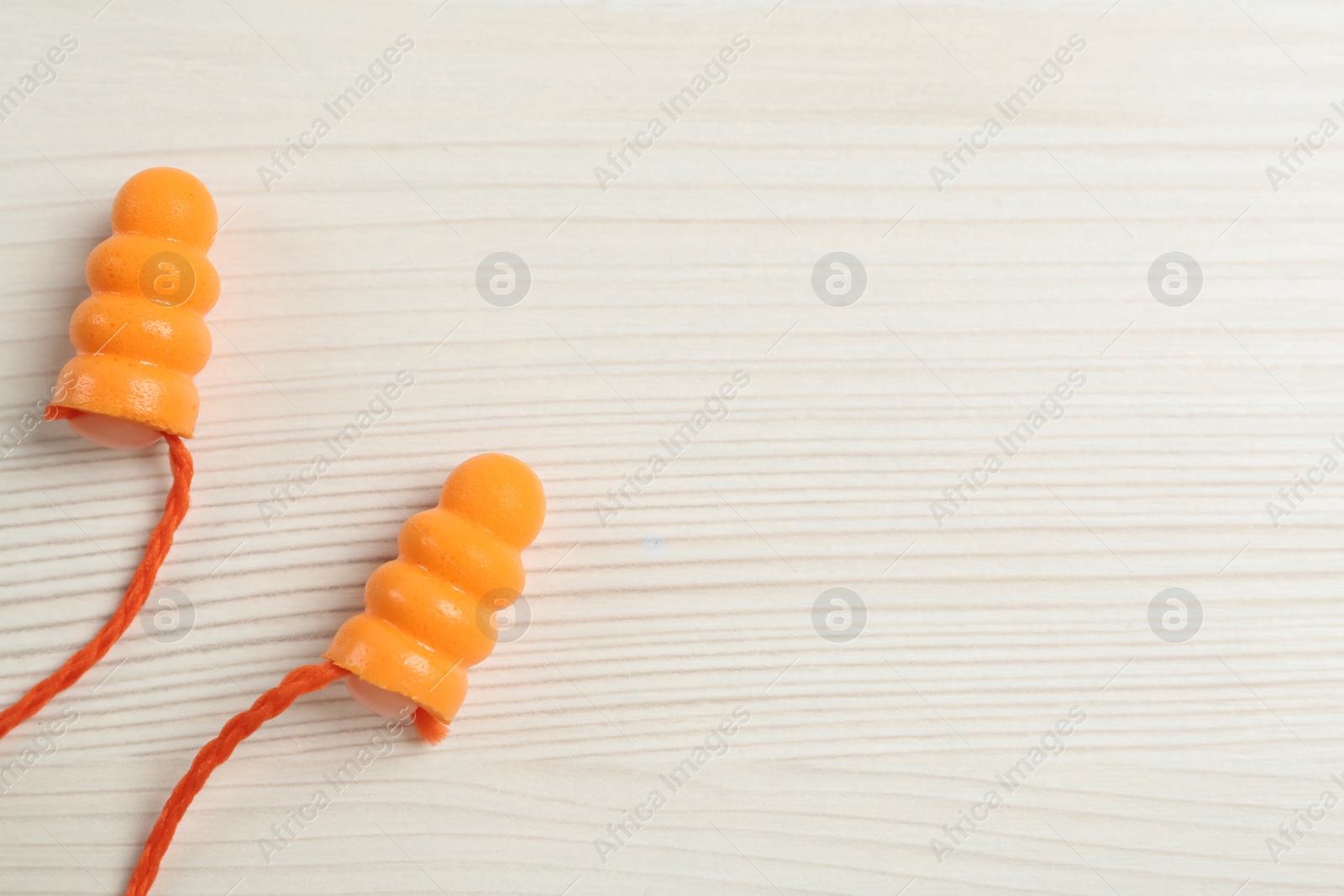 Photo of Pair of ear plugs on white wooden background, flat lay. Space for text