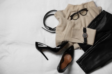 Photo of Stylish look with cashmere sweater, flat lay. Women's clothes and accessories on fabric
