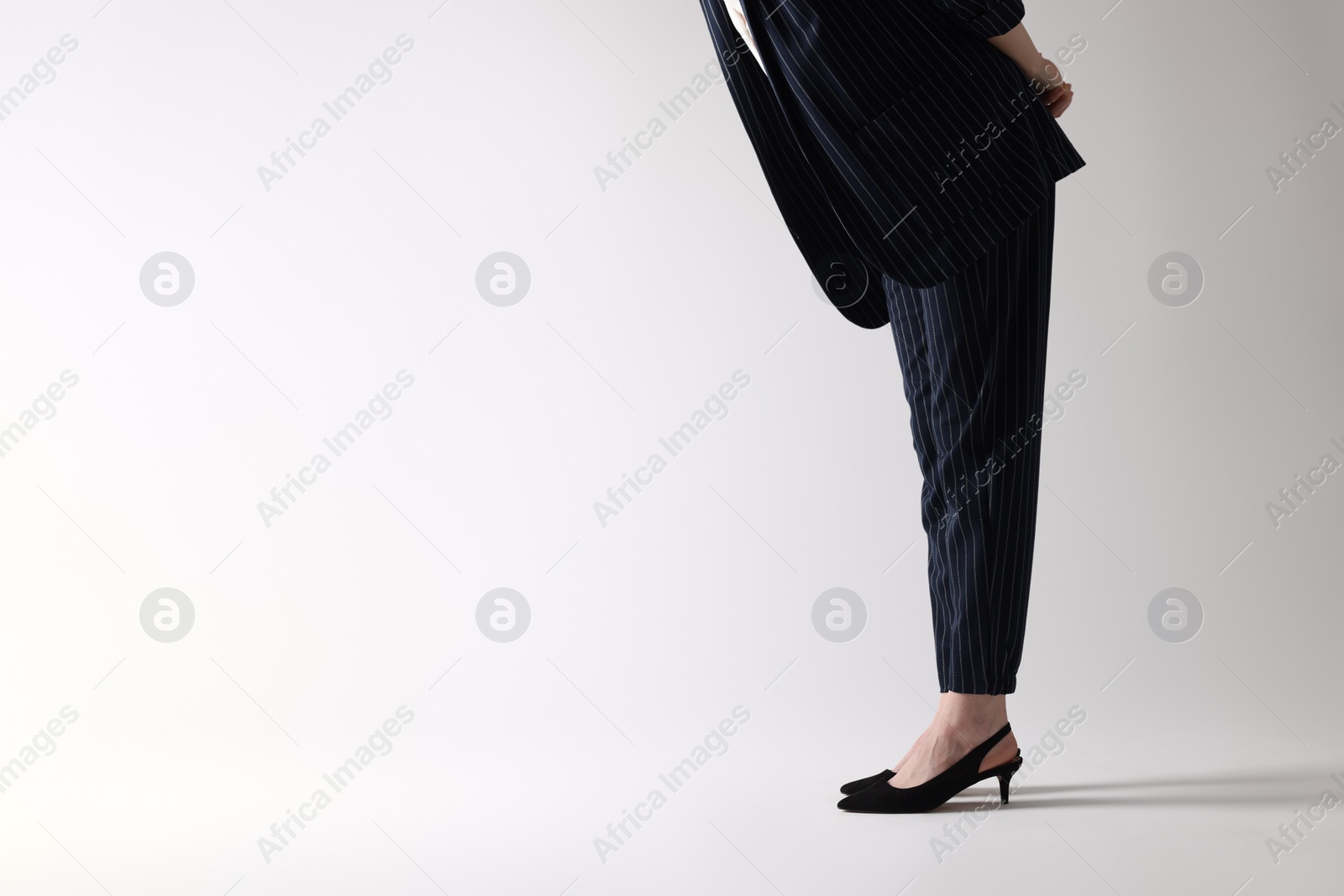 Photo of Businesswoman in black shoes on white background, closeup