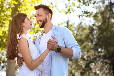 Photo of Lovely young couple dancing together in park on sunny day