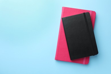 Photo of Different notebooks on light blue background, top view. Space for text