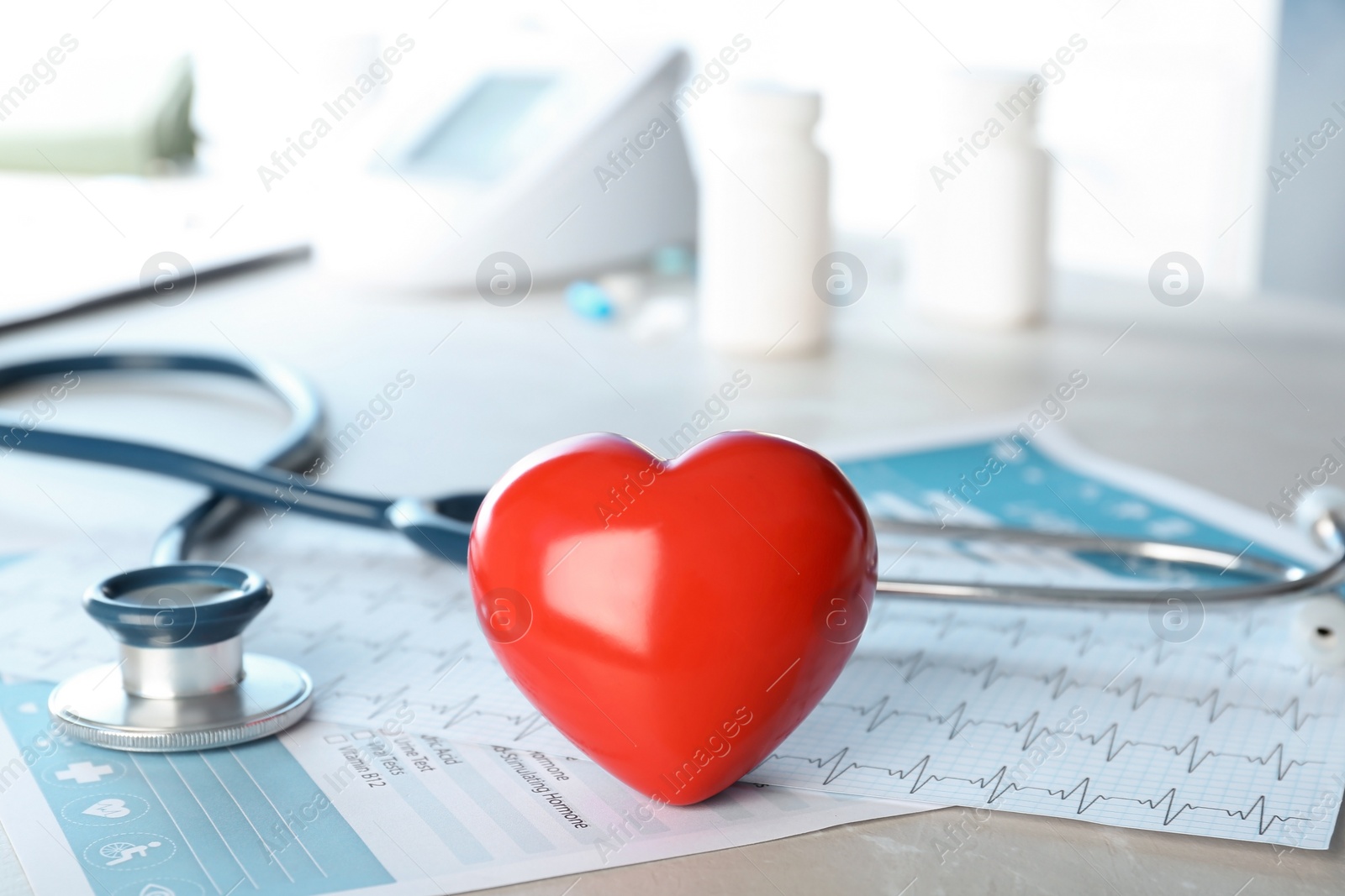 Photo of Stethoscope and heart model on table. Cardiology service