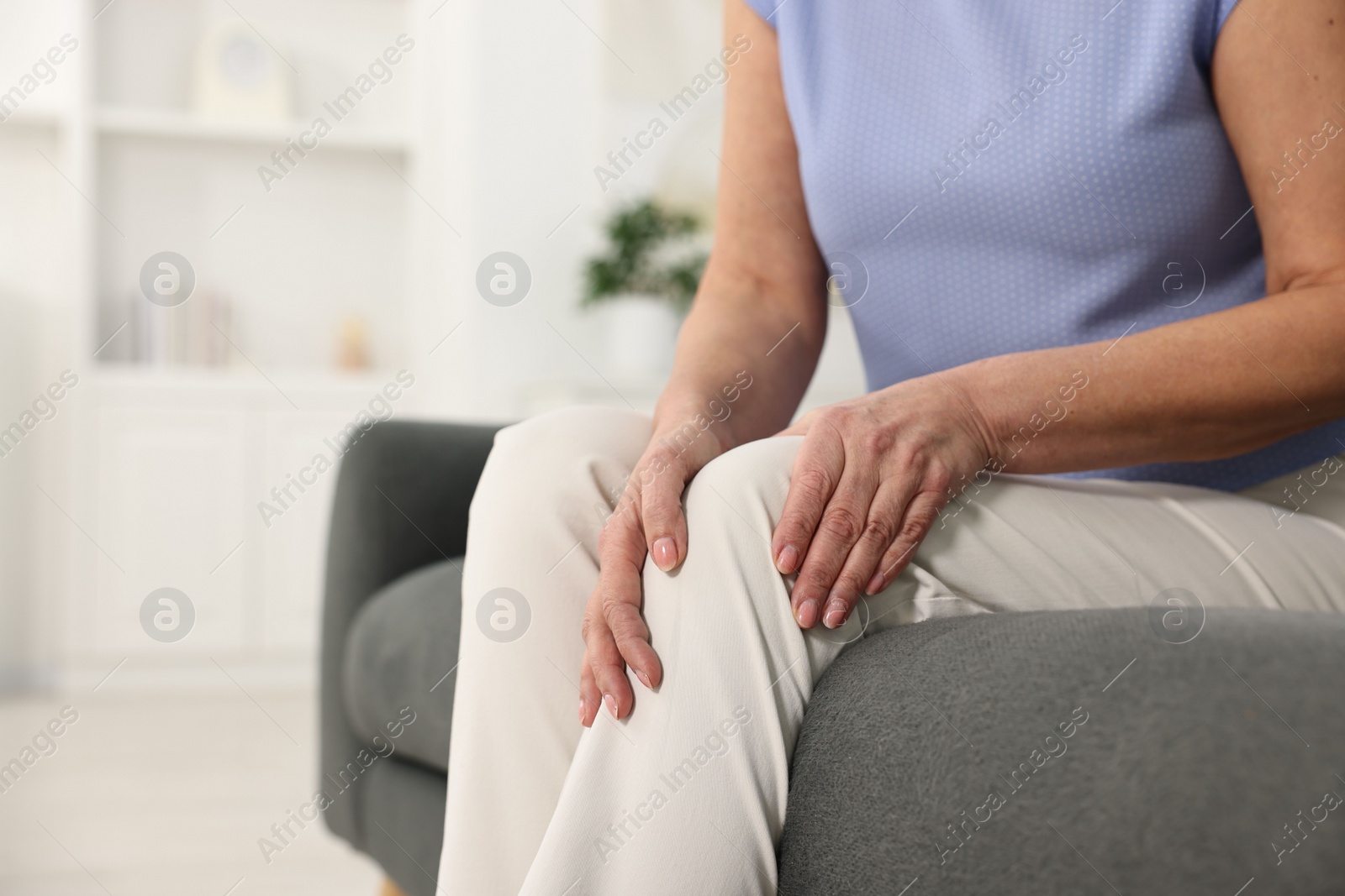 Photo of Arthritis symptoms. Woman suffering from pain in knee at home, closeup