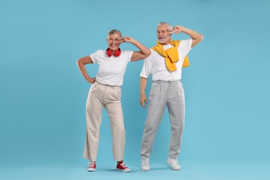 Photo of Senior couple dancing together on light blue background