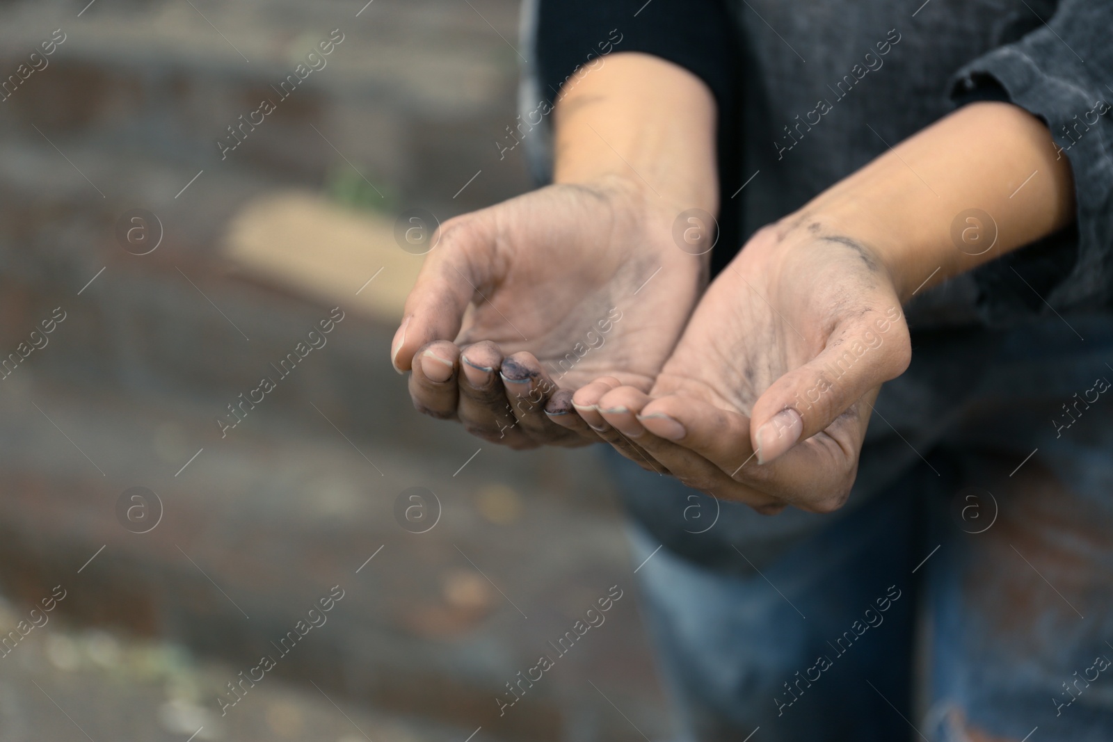 Photo of Poor homeless woman begging for help outdoors, closeup