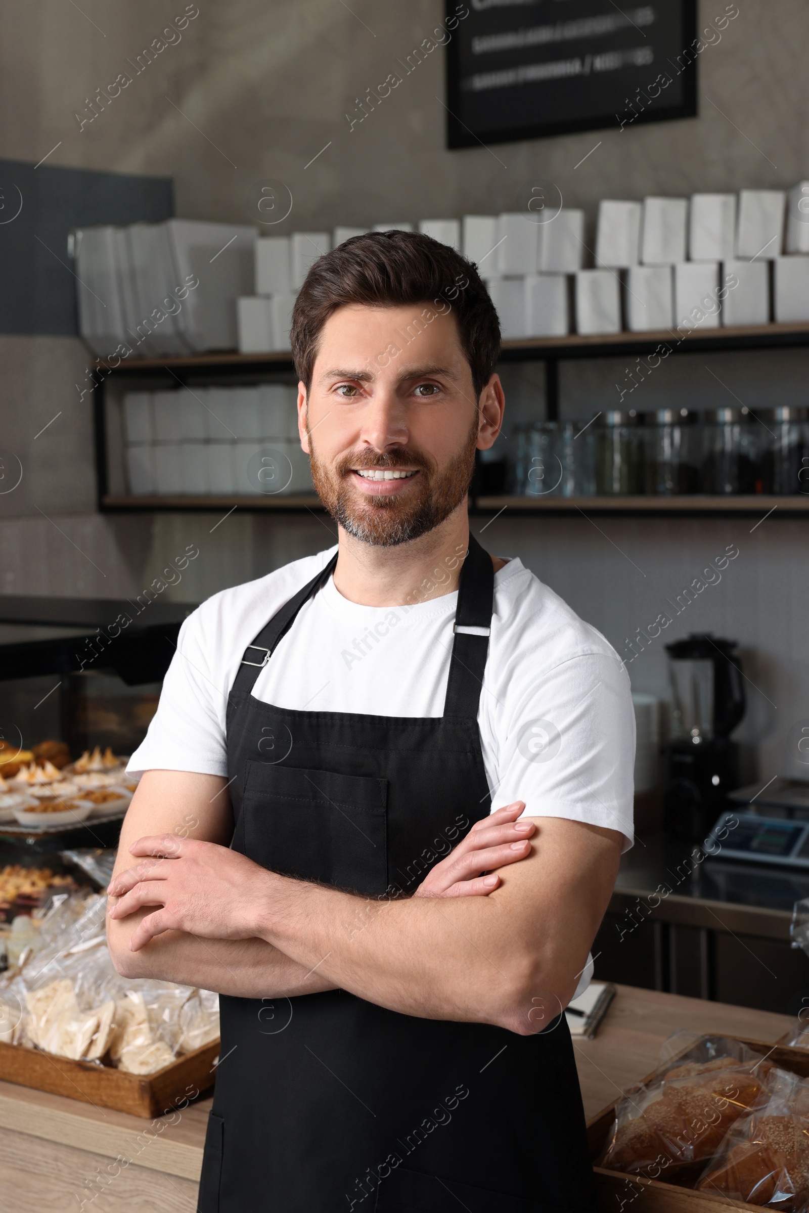 Photo of Portrait of happy seller in bakery shop