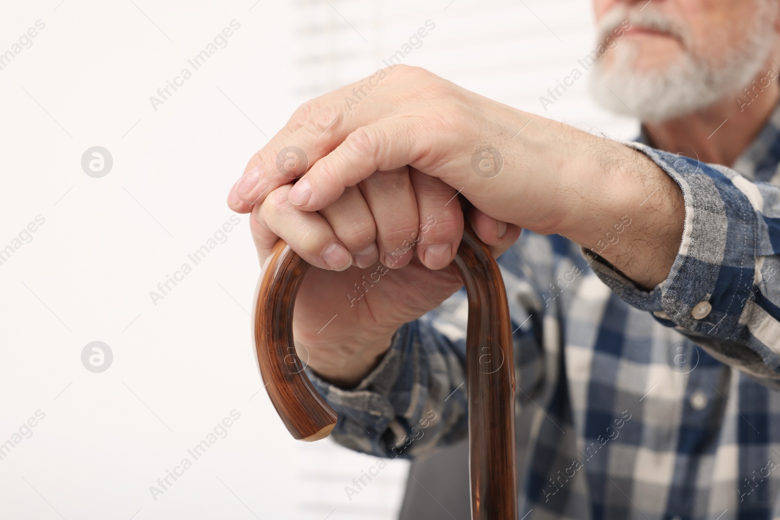 Photo of Senior man with walking cane at home, closeup. Space for text