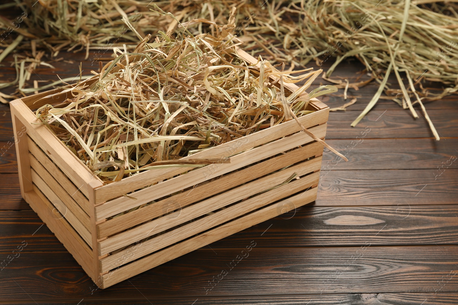 Photo of Dried hay in crate on wooden table