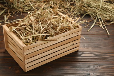 Dried hay in crate on wooden table