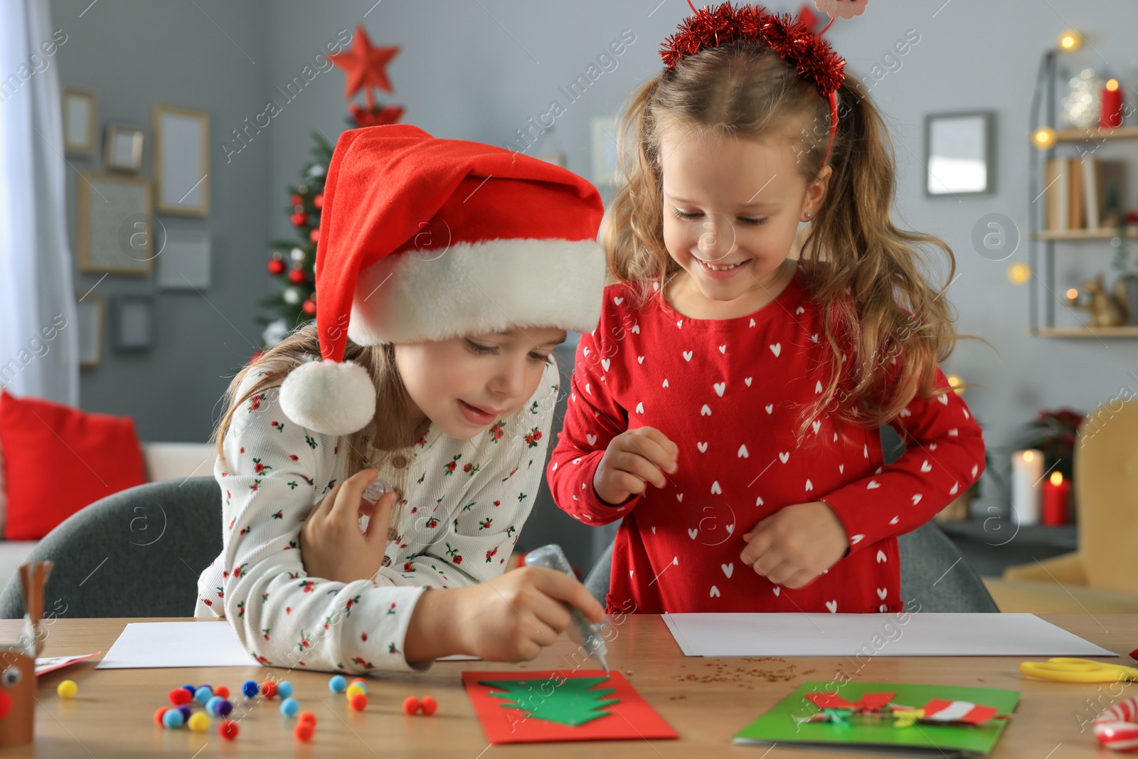 Photo of Cute little children making beautiful Christmas greeting cards at home