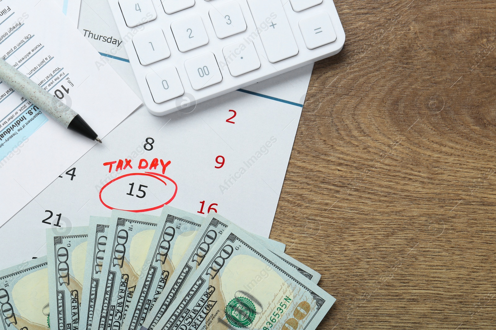 Photo of Calendar with date reminder about tax day, documents, pen, money and calculator on wooden table, flat lay. Space for text