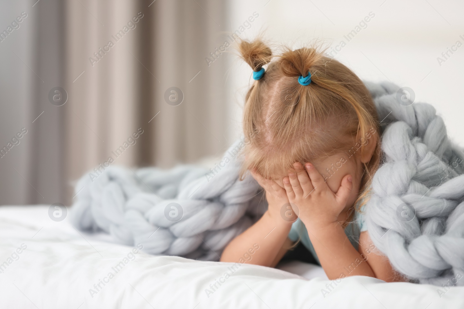 Photo of Cute little girl lying on bed at home