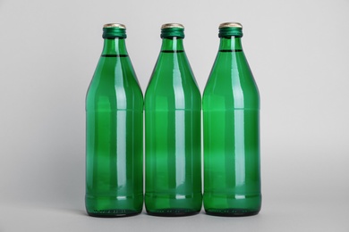Photo of Glass bottles with water on white background