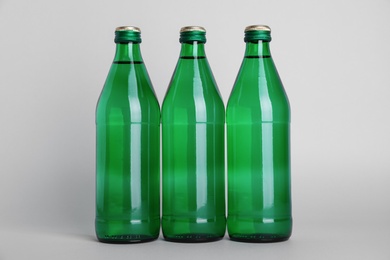 Glass bottles with water on white background