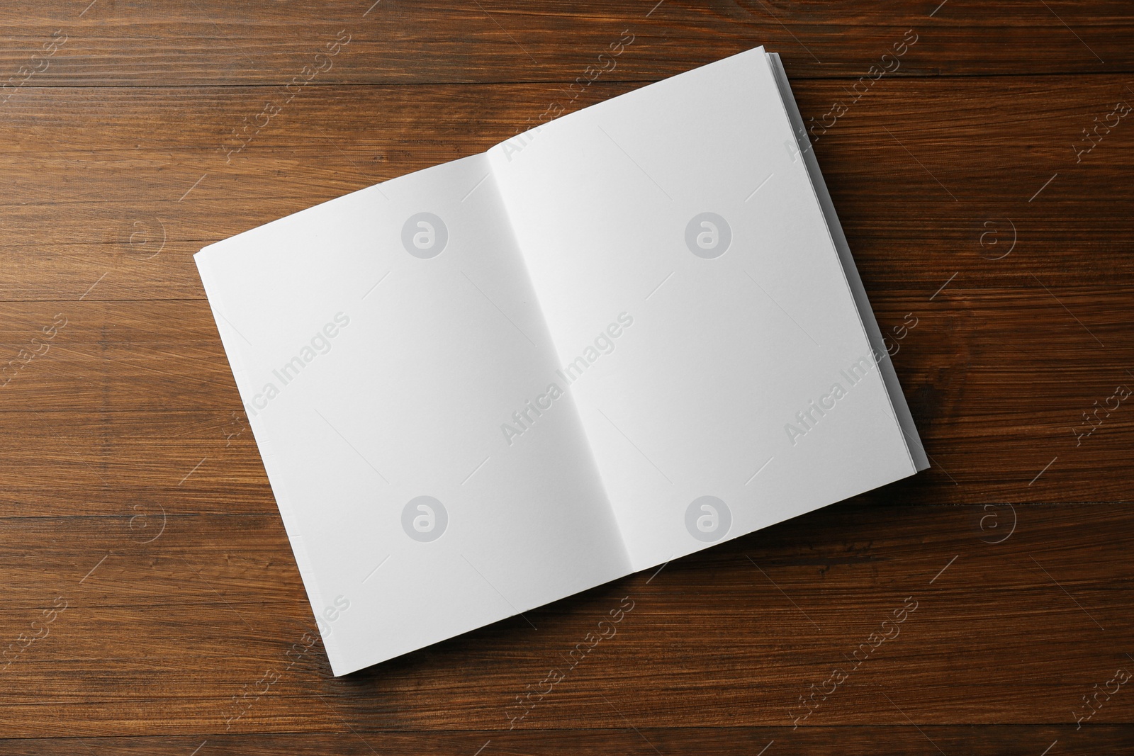 Photo of Open blank paper brochure on wooden table, top view. Mockup for design