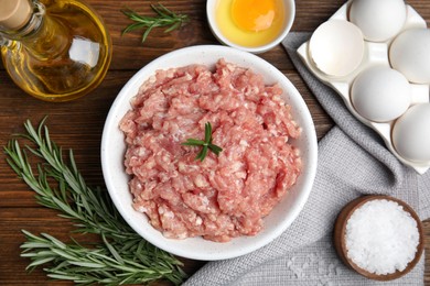 Raw chicken minced meat and ingredients on wooden table, flat lay