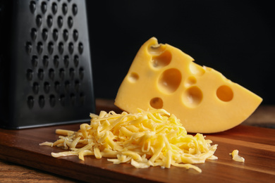 Tasty grated cheese on wooden table, closeup