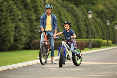 Dad and son riding modern bicycles outdoors