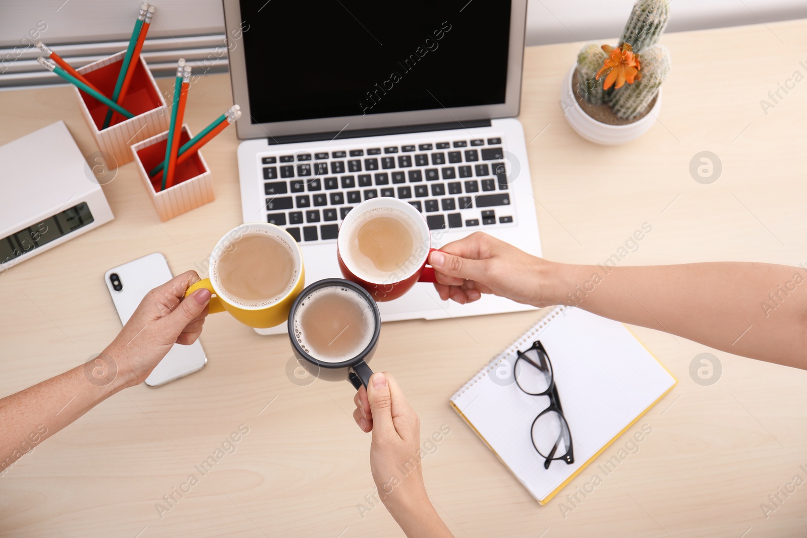 Photo of Women holding cups of coffee over table, top view. Break time