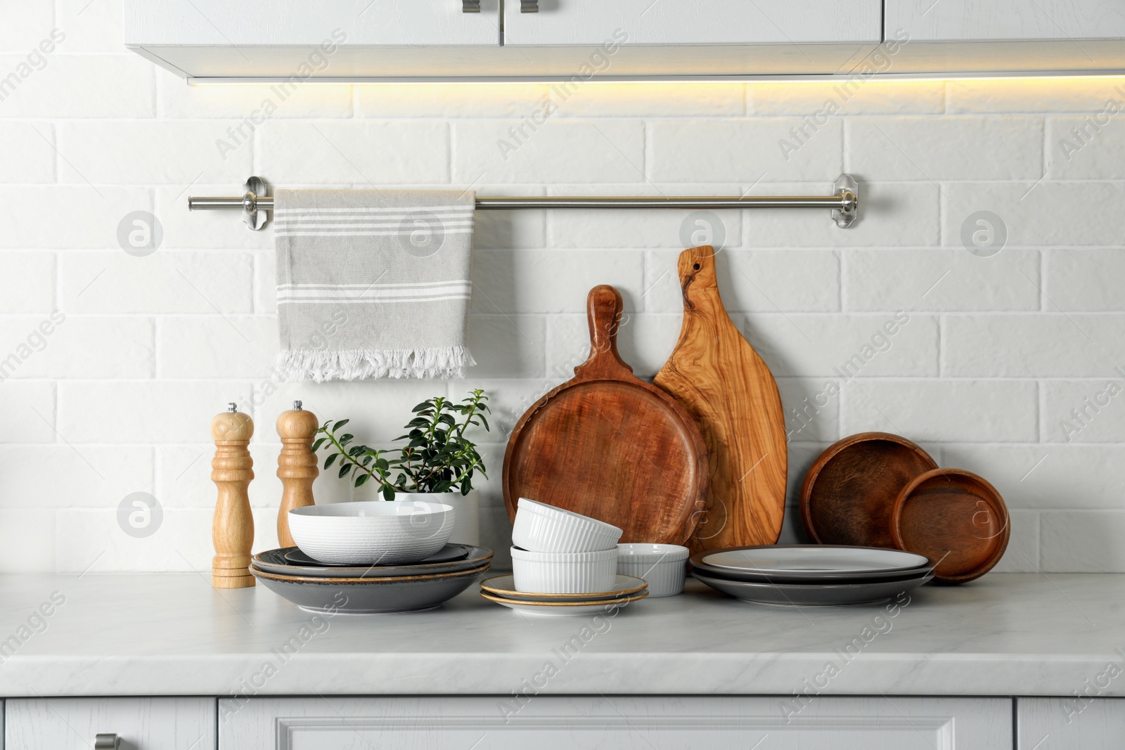 Photo of Set of clean tableware on white countertop in kitchen