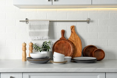 Set of clean tableware on white countertop in kitchen